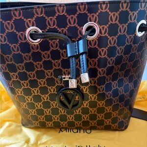 Genuine Valentino leather bucket bag with center zip, inside pocket, and strap.